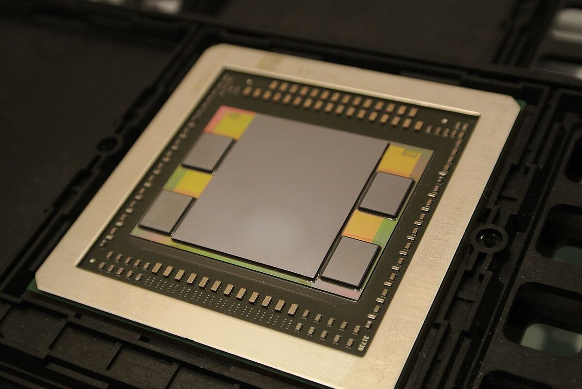 A GPU package: a large GPU die surrounded by four stacked high-bandwidth memory chips on a silicon interposer.